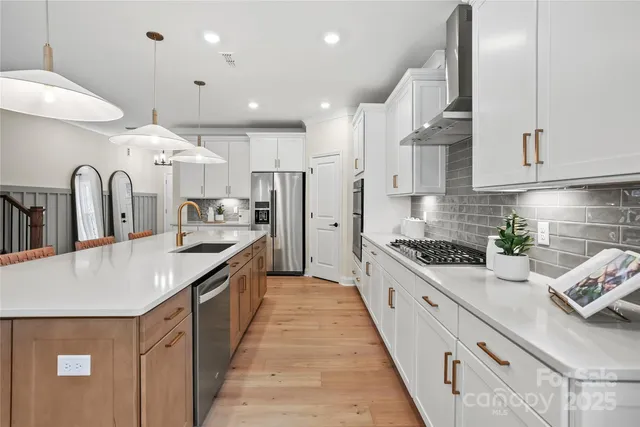 a large kitchen with stainless steel appliances lots of counter space and a sink