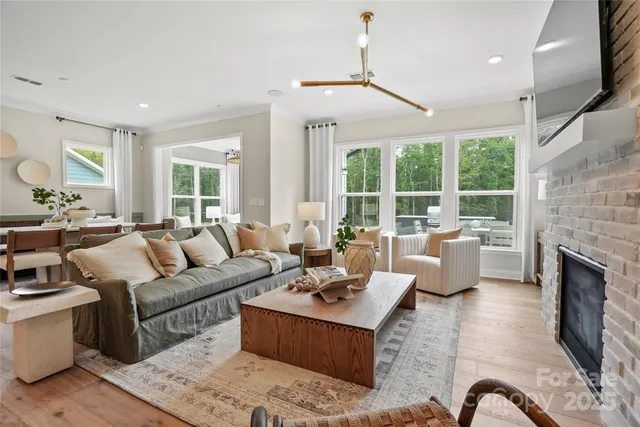 a living room with furniture fireplace and a large window