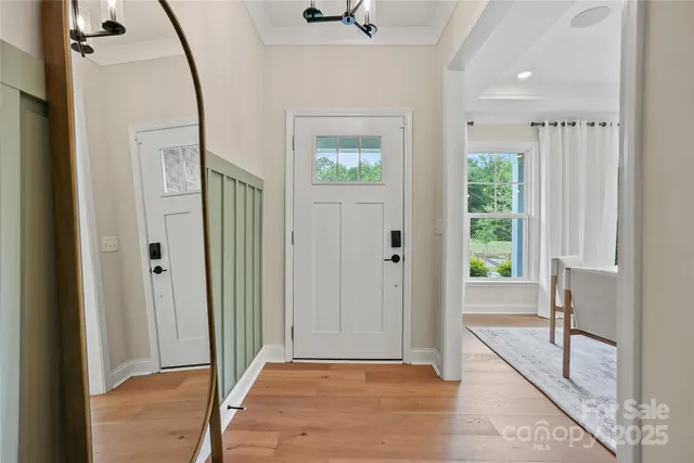 a view of a hallway with wooden floor and a bathroom