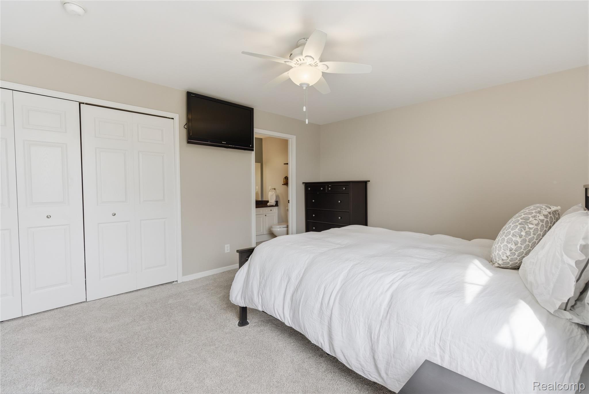 3402 Tremonte Circle Rochester, MI 48306 - Photo 16 of 37 Bedroom with light carpet, a ceiling fan, a closet, and ensuite bath