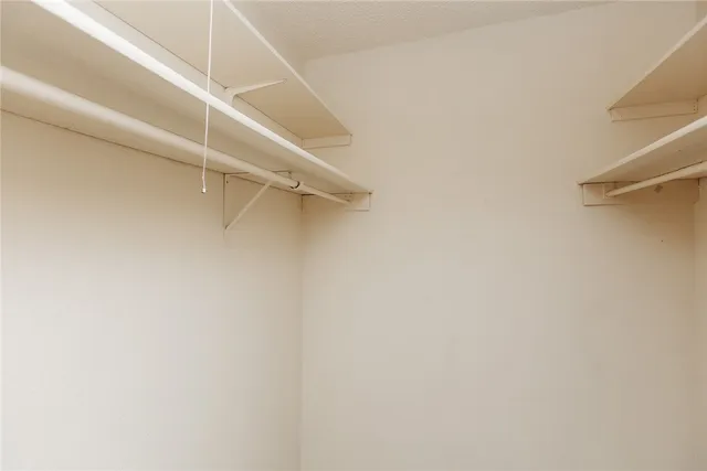 a view of walk in closet with empty racks