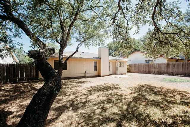 a tree in front of a white house