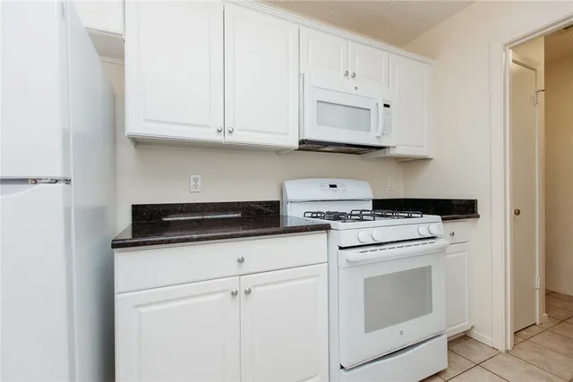 a kitchen with white cabinets and white appliances