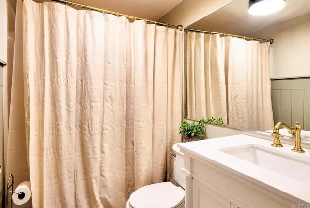 a bathroom with a sink mirror vanity and toilet