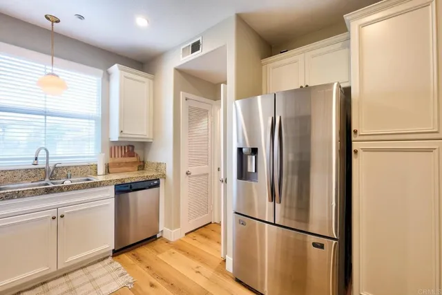 a kitchen with a refrigerator a sink and cabinets