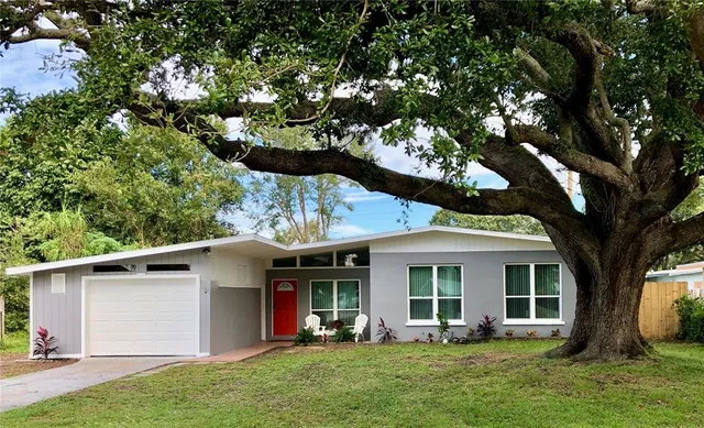 a view of a house with a yard and sitting area