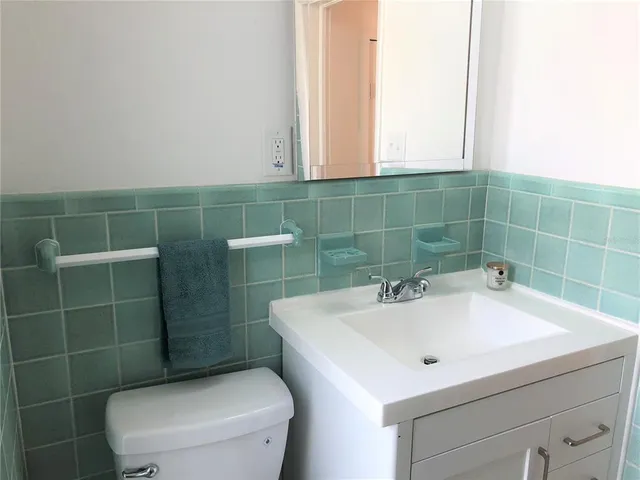 a bathroom with a sink a toilet and a mirror