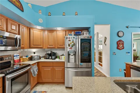 a kitchen with stainless steel appliances granite countertop a refrigerator and a stove top oven
