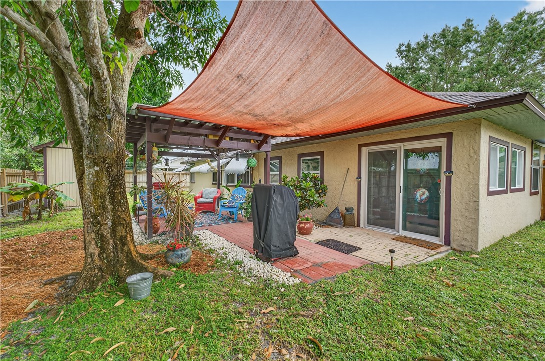 1361 Clearbrook Street Sebastian, FL 32958 - Photo 26 of 29 a view of a patio with table and chairs under an umbrella