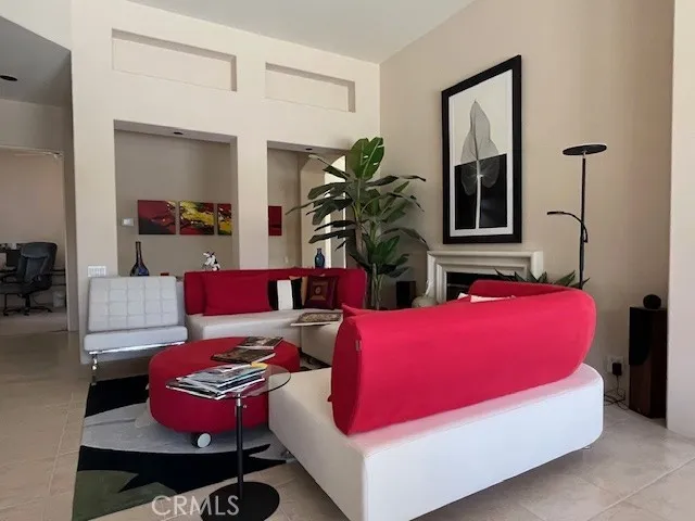 a living room with furniture a window and potted plants