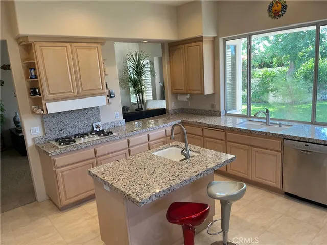a large kitchen with stainless steel appliances granite countertop a sink counter space cabinets and a large window