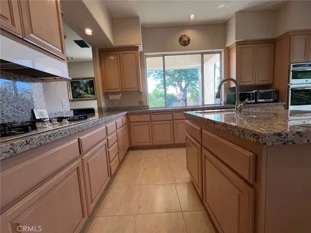 a kitchen with granite countertop a refrigerator and a sink