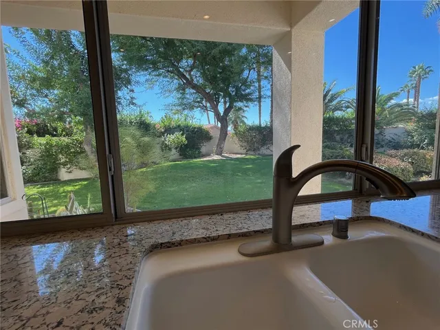 a large kitchen with granite countertop a stove sink and cabinets