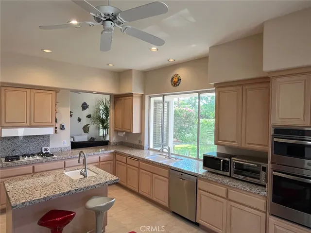 a bathroom with a granite countertop sink a toilet a mirror and window