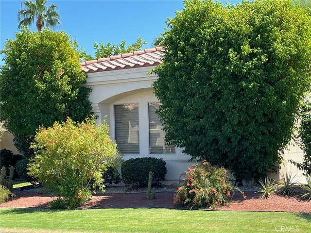 a front view of a house with a garden and entryway