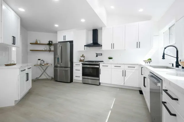 a kitchen with white cabinets and stainless steel appliances