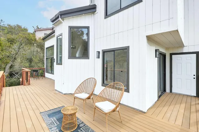 a view of a house with wooden deck and furniture