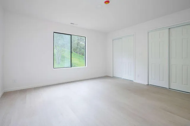 an empty room with windows and closet