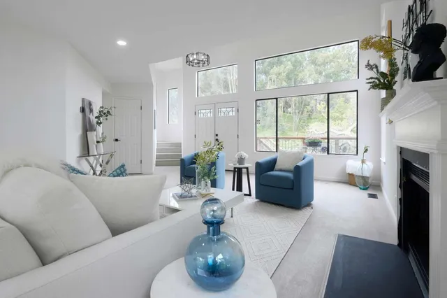 a living room with furniture fireplace and a large window