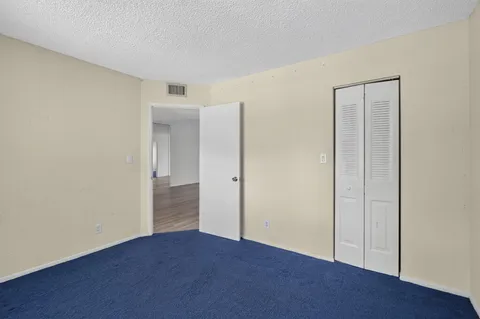 an empty room with closet and wooden floor