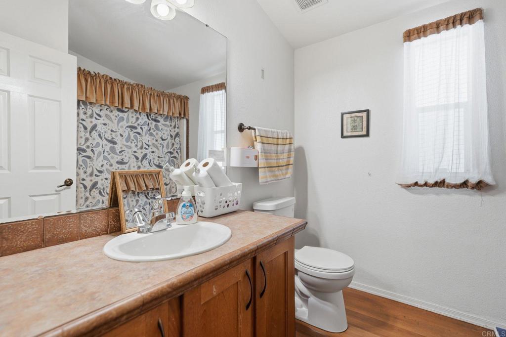 10767 Jamacha Boulevard, Unit SPC 119 Spring Valley, CA 91978 - Photo 14 of 25 a bathroom with a sink a toilet and mirror