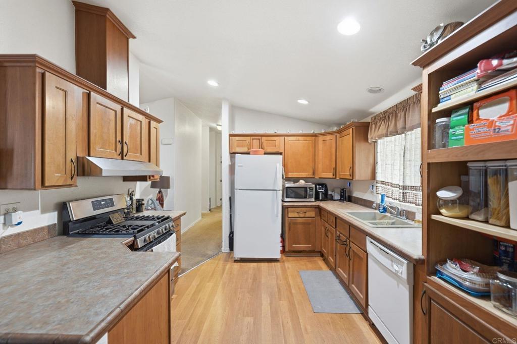 10767 Jamacha Boulevard, Unit SPC 119 Spring Valley, CA 91978 - Photo 7 of 25 a kitchen with a refrigerator a sink and a stove top oven