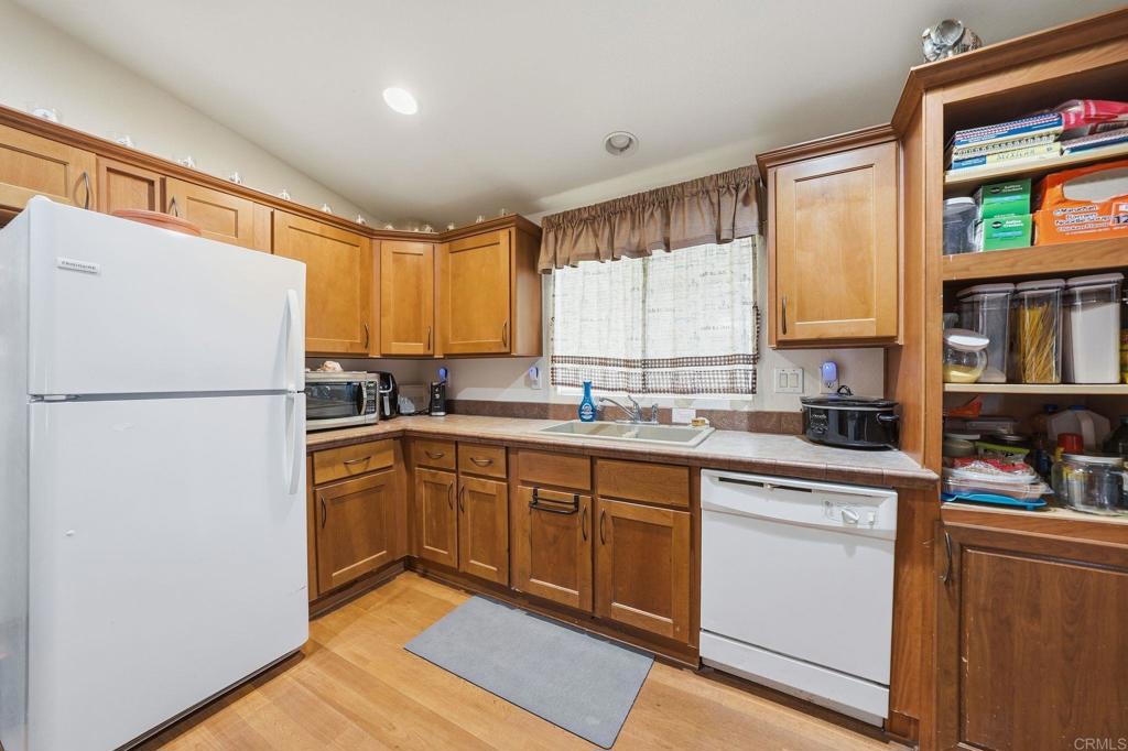10767 Jamacha Boulevard, Unit SPC 119 Spring Valley, CA 91978 - Photo 9 of 25 a kitchen with a refrigerator a sink and cabinets