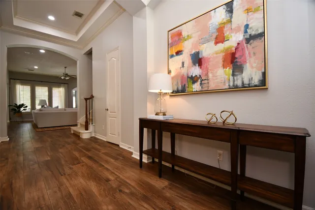 a view of a hallway with wooden floor and furniture