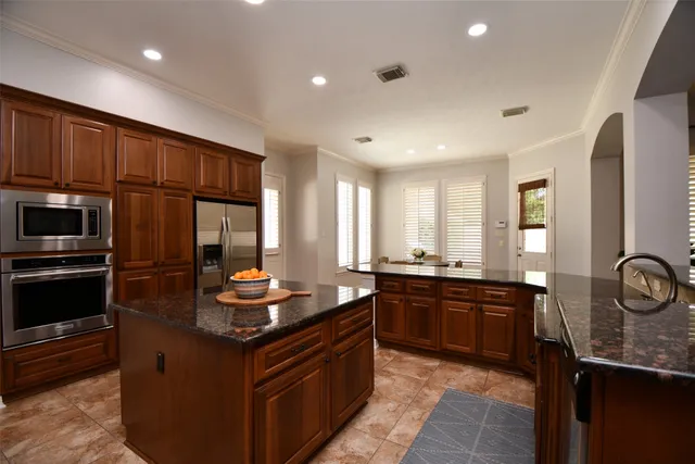 a kitchen with granite countertop a sink stove and refrigerator