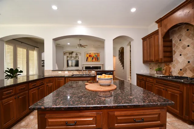 a large kitchen with granite countertop a sink and cabinets
