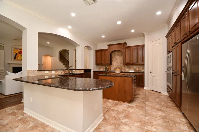 a kitchen with stainless steel appliances granite countertop a sink and a refrigerator