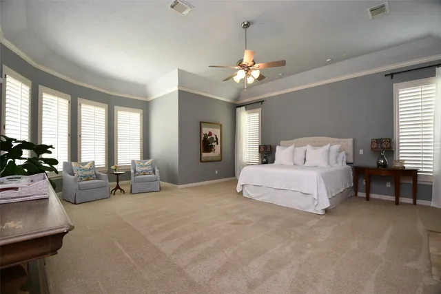 a spacious bedroom with a bed a couch and a chandelier