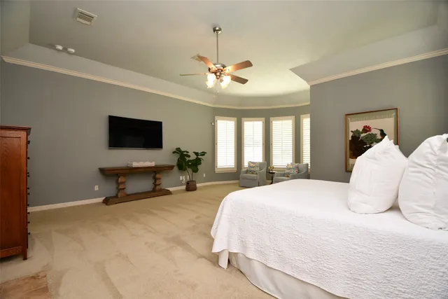 a spacious bedroom with a bed and a flat screen tv