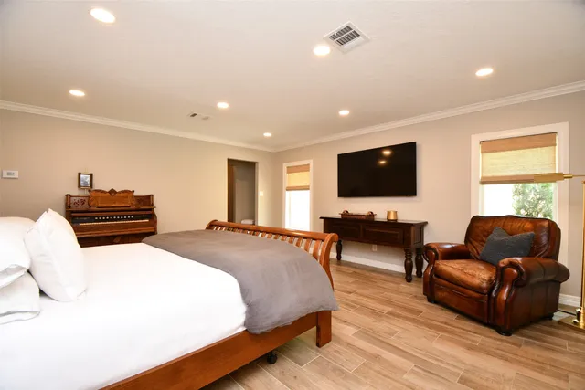 a spacious bedroom with a bed and a flat screen tv