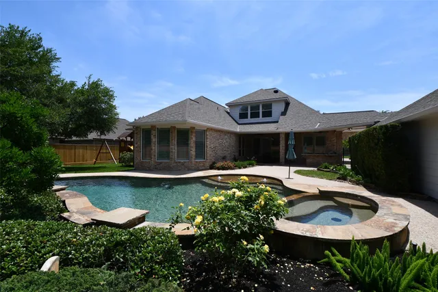 a front view of a house with swimming pool and garden