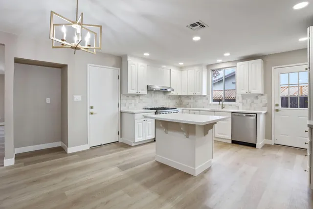 a kitchen with a sink cabinets a window and stainless steel appliances