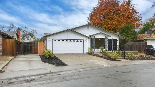 a front view of a house with garden and plants