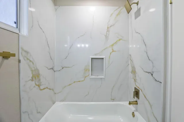 a bathroom with a bathtub and shower