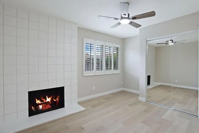 a view of an empty room with window and fireplace