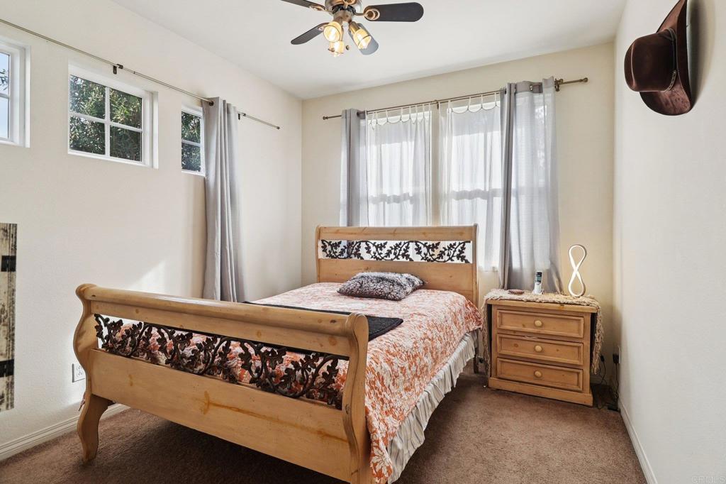 5544 Mill Creek Road San Diego, CA 92130 - Photo 12 of 54 a bedroom with a bed a window and a chandelier