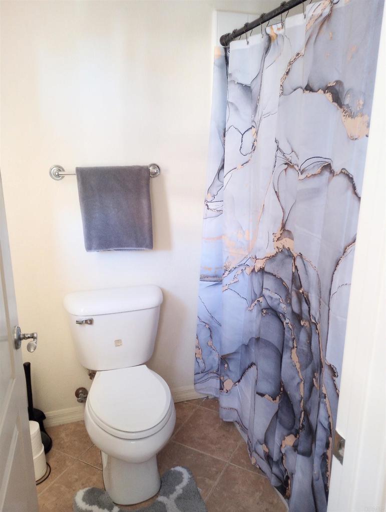 5544 Mill Creek Road San Diego, CA 92130 - Photo 33 of 54 a white toilet sitting next to a shower curtain