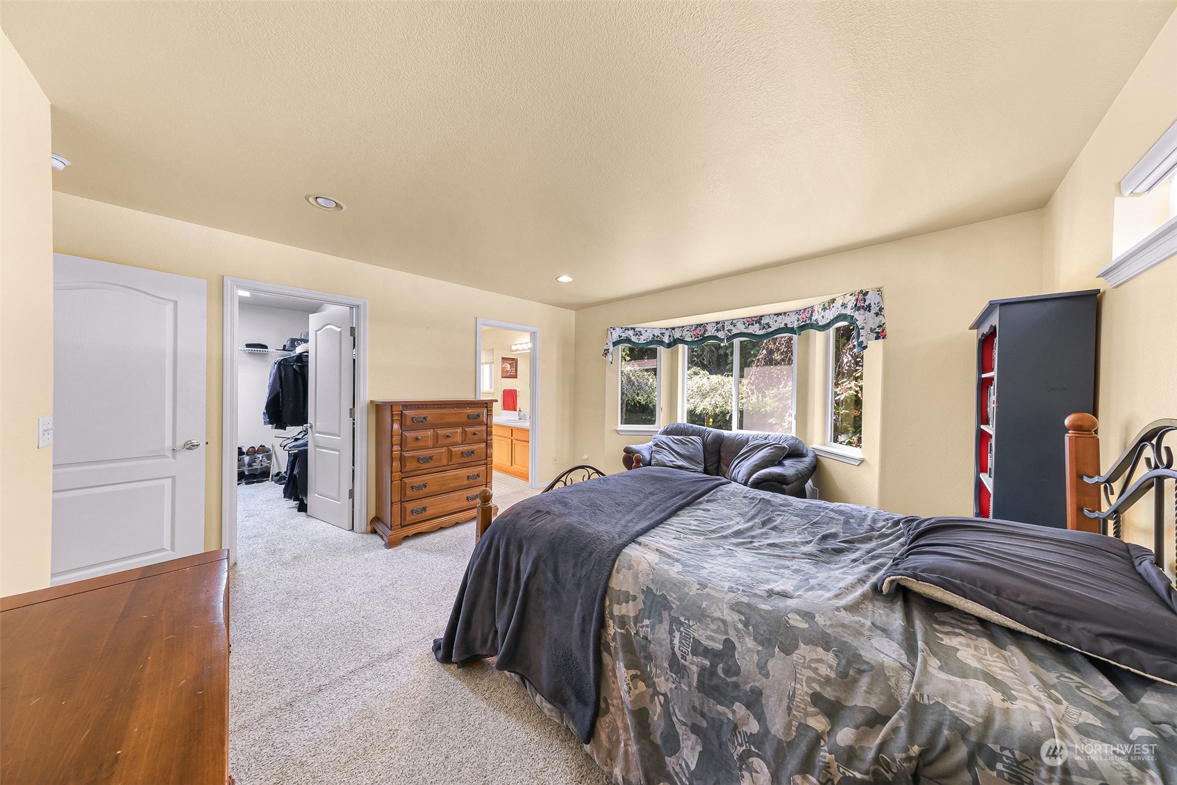 3827 Copper Pond Anacortes, WA 98221 - Photo 13 of 26 a spacious bedroom with a bed a dresser and a large window