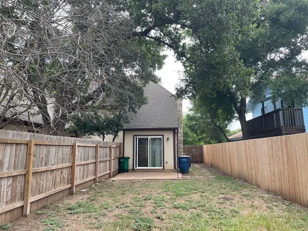 a view of a house with a yard and large tree