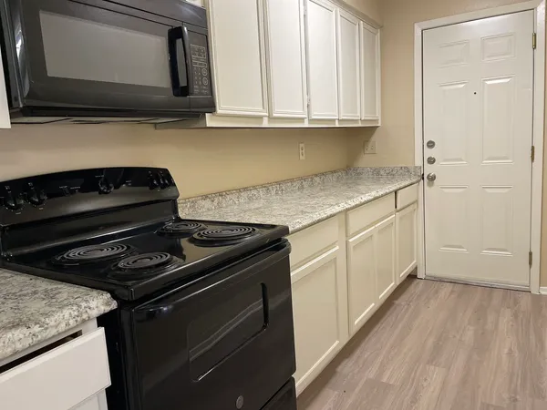 a kitchen with granite countertop a stove and a microwave