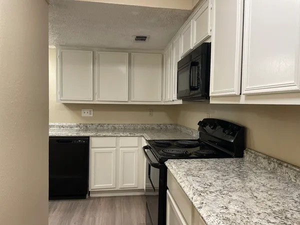 a kitchen with a stove and a granite counter top