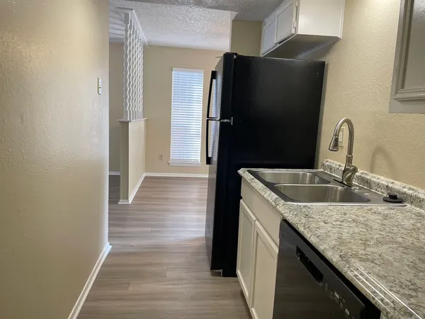 a kitchen with granite countertop a refrigerator and a sink