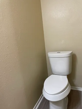 a white toilet sitting next to a white wall