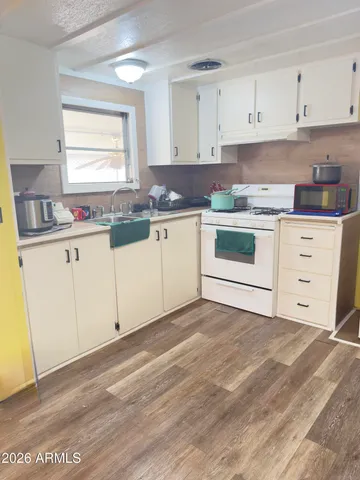 a kitchen with granite countertop white cabinets and white appliances