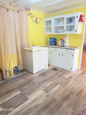 a view of a kitchen with fridge and wooden floor