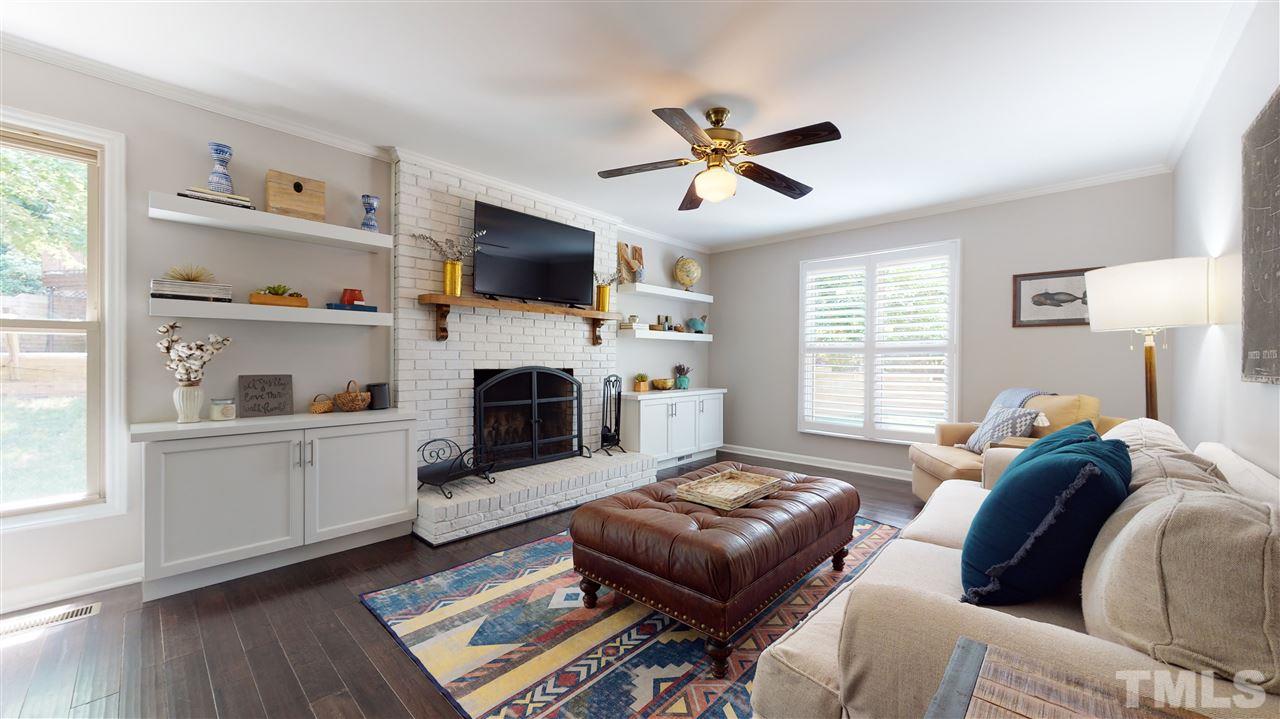 2104 Chrisdale Court Raleigh, NC 27607 - Photo 12 of 29 a living room with furniture a flat screen tv and a fireplace